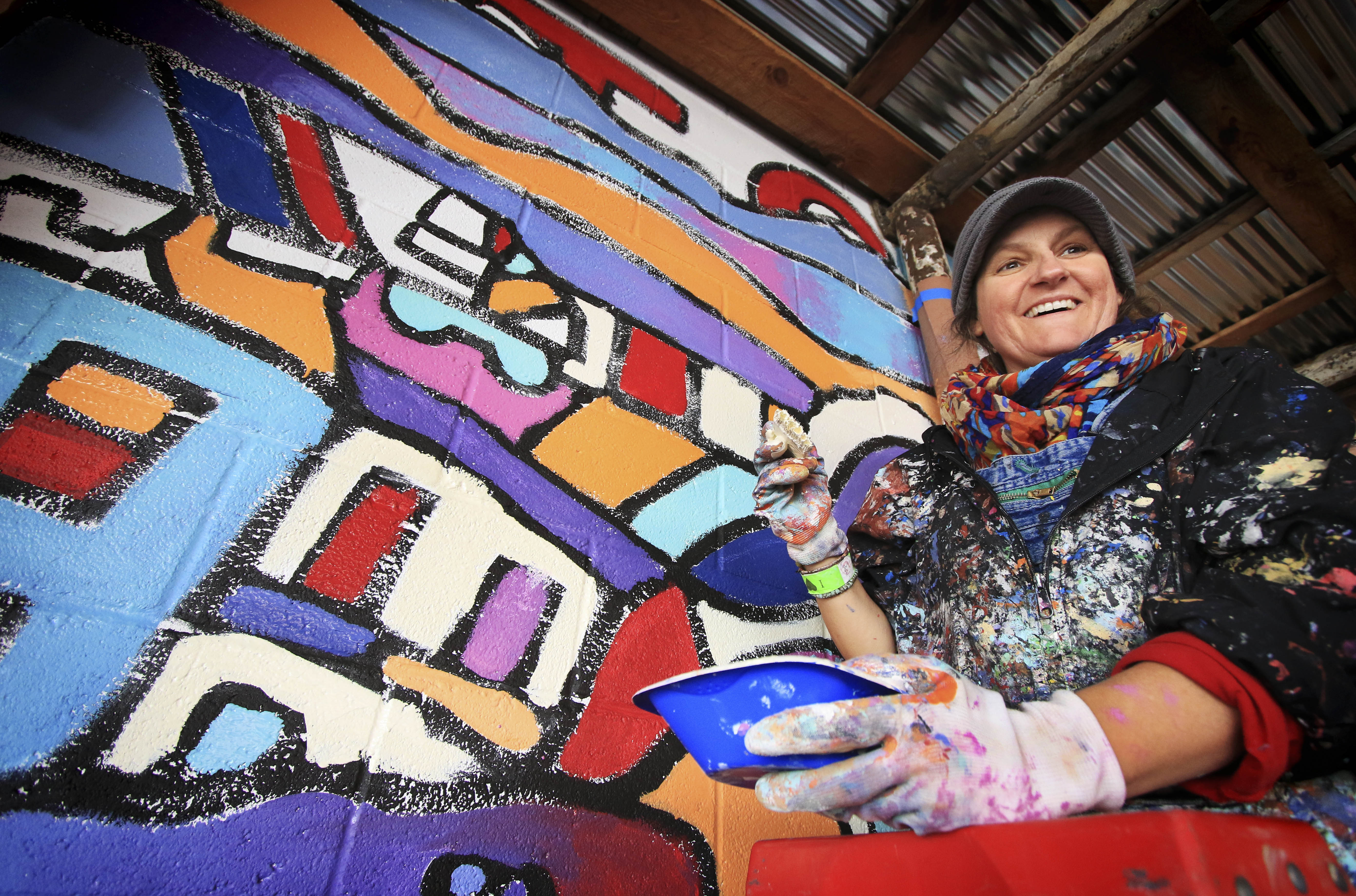 Tennesse mural artist Andee Rudloff works on a mural in alley behind Out of the Blue Antiques with a group of Park High School students in downtown Livingston on Tuesday afternoon.